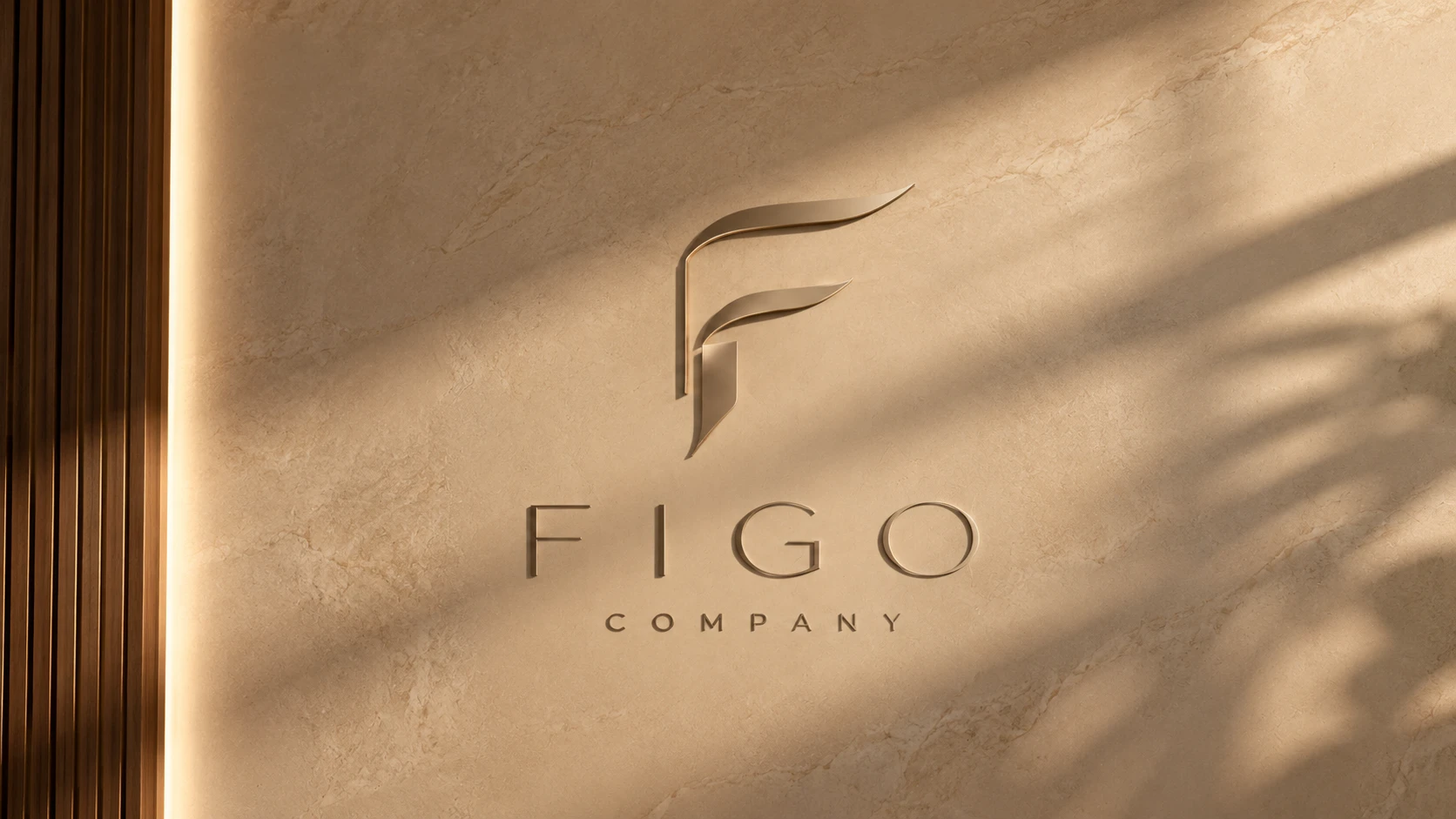 Logo da Figo Company em relevo numa parede de pedra com sombra de palmeira